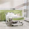 Aura Lite Spring Assisted Height Adjustable Over-bed Table in White hospital scene